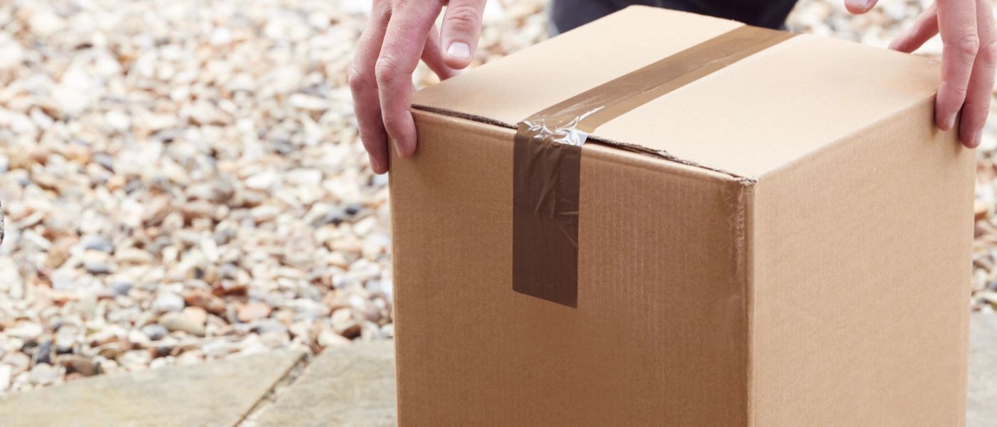 Delivery service driver handing package at residential door