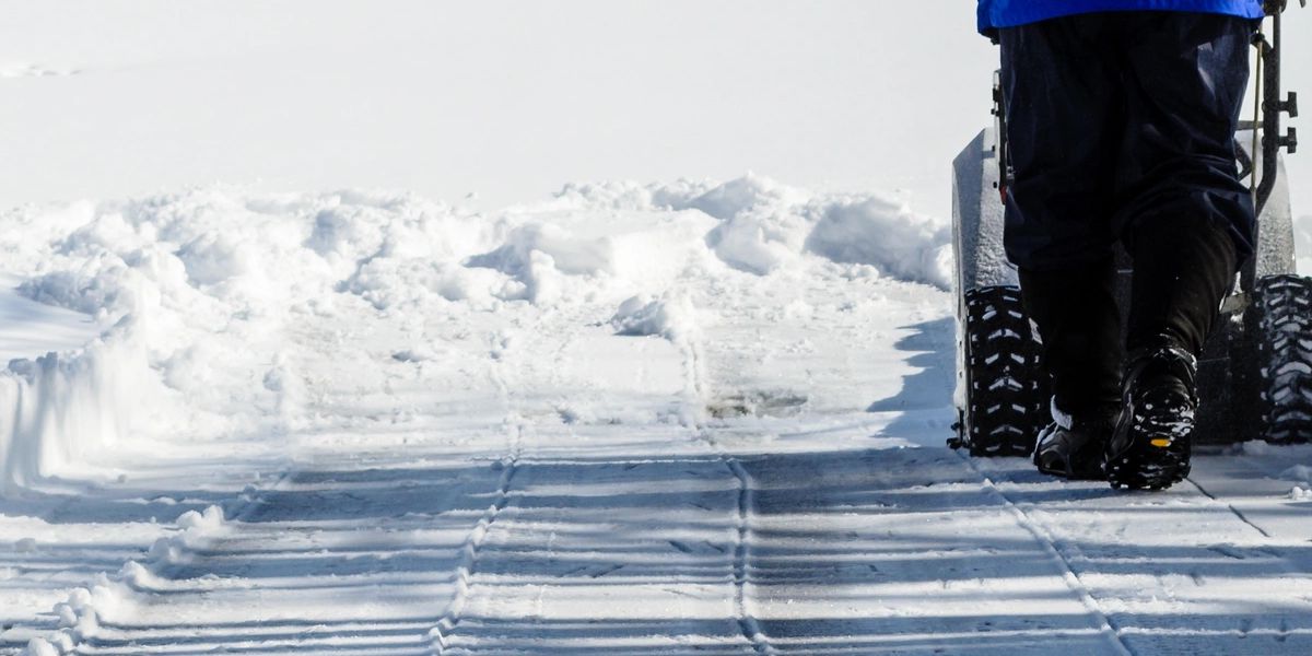 Snow removal crew clearing driveway winter residential
